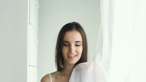 Mooi sexy meisje van tikje poseren in camera en smililng in de buurt van venster — Stockvideo