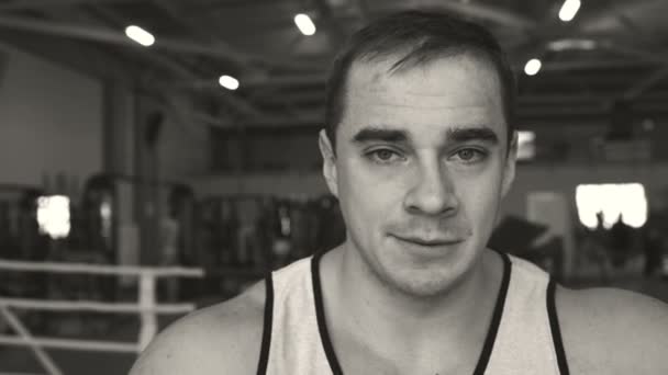 Young man in the boxing ring. Sportsman looking at the camera . Black and white portrait — Stock Video