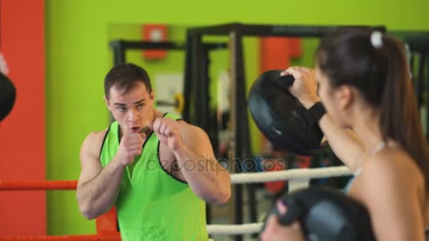 Pociąg człowieka trener kick-boxingu z młodą kobietę w ringu — Wideo stockowe