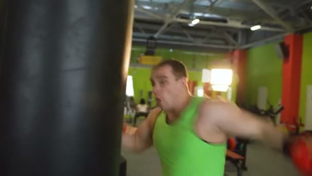 Young boxer man practicing on a punching bag — Stock Video