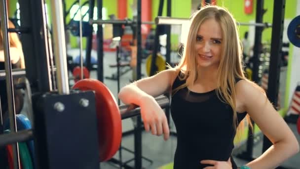 Femme blonde sportive forte souriant et regardant dans la caméra dans le club de remise en forme — Video