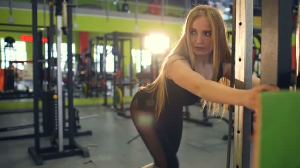 Strong blonde woman doing exercise wtiht lifting weights in fitnest club — Stock Video