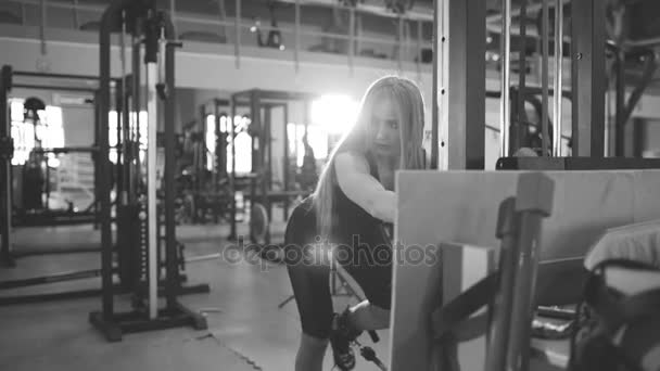 Silná blond žena dělá cvičení wtiht tréninků v fitnest klubu