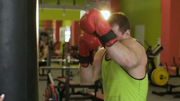 Slow motion van jonge bokser man beoefenen op een bokszak — Stockvideo