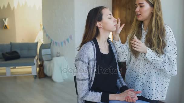 Joven maquillador hace que una chica hermosa maquillaje para la cara antes de un evento importante — Vídeos de Stock