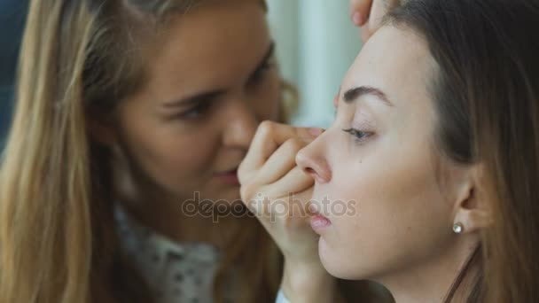Joven maquillador hace que una chica hermosa maquillaje para los ojos primer plano antes de un evento importante — Vídeos de Stock
