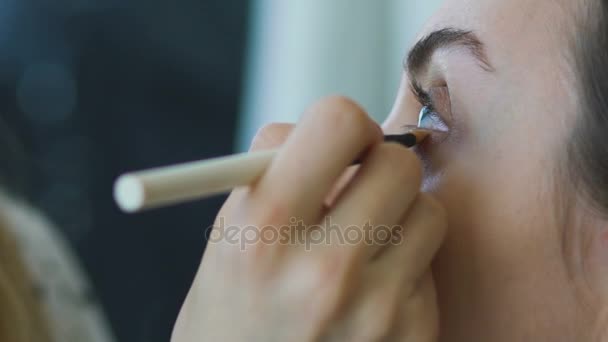 Slow motion van jonge Visagist maakt een meisje mooie make-up close-up vóór een belangrijke gebeurtenis — Stockvideo