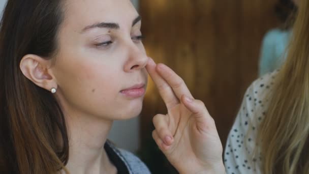 Slow motion van jonge Visagist maakt een meisje mooie make-up close-up vóór een belangrijke gebeurtenis — Stockvideo