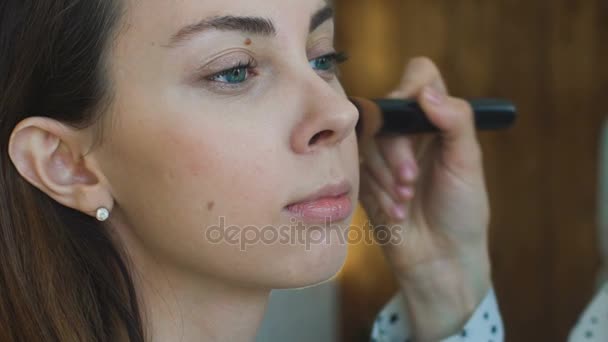 Movimento lento do jovem maquiador faz uma menina bela maquiagem close-up antes de um evento importante — Vídeo de Stock