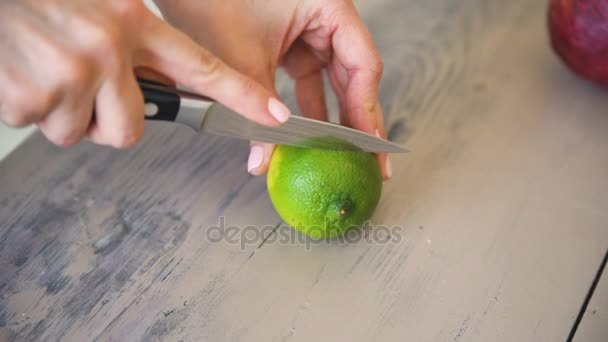 Menschliche Hände schneiden eine Scheibe Limette in Stücke für die Zubereitung von Mojito-Cocktail in der Küche — Stockvideo