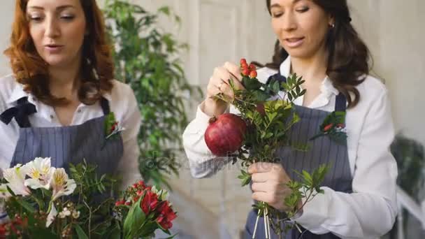 Dos floristas guapos jóvenes del chef trabajan en la tienda de frutas de las flores haciendo el ramo de frutas y verduras — Vídeos de Stock