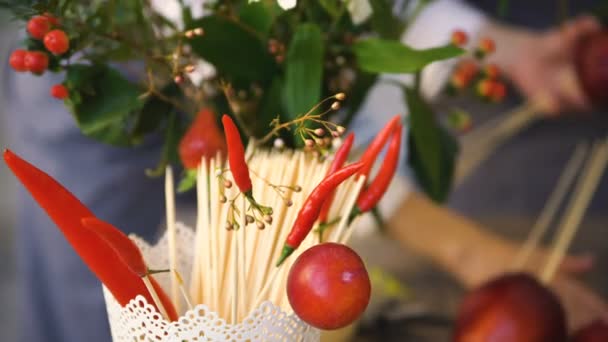Ведро с чили и деревянными палочками для еды на фоне работы флористов-поваров — стоковое видео