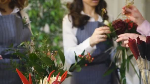 Három fiatal szép chef virágkereskedések dolgozni, így a gyümölcs- és zöldségágazat csokor virágot gyümölcs boltban — Stock videók