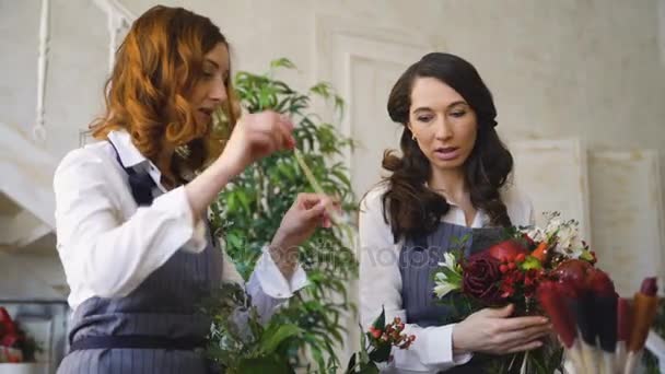 Drei junge, gut aussehende Koch-Floristen arbeiten im Blumengeschäft und stellen Obst- und Gemüsebouquet her — Stockvideo