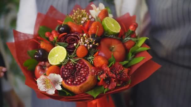 Woman rotating bouquet of fruits: lime, strawberry, pomegranate, marshmallow, apple — Stock Video
