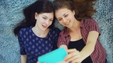 İki güzel kız yatakta evde yatak odasında selfie portre yapmak pijama Üstten Görünüm