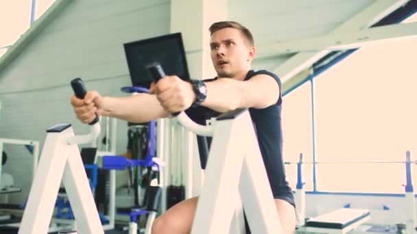 Bonito homem desportivo está se exercitando no clube de fitness e centro de fitness — Vídeo de Stock