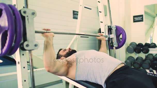 Handsome sporty man is exercising in fitness club and gym center — Stock Video