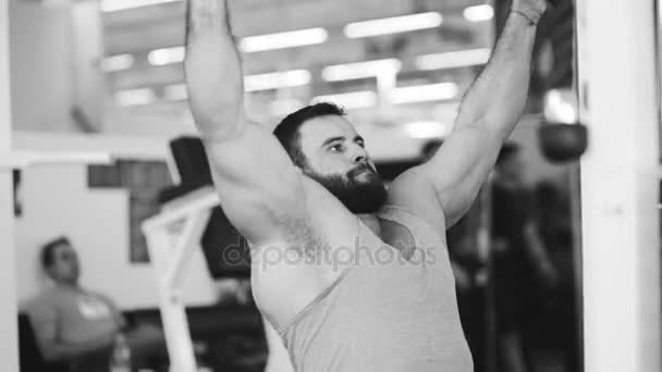 Hombre deportivo guapo está haciendo ejercicio en el gimnasio y gimnasio — Vídeo de stock