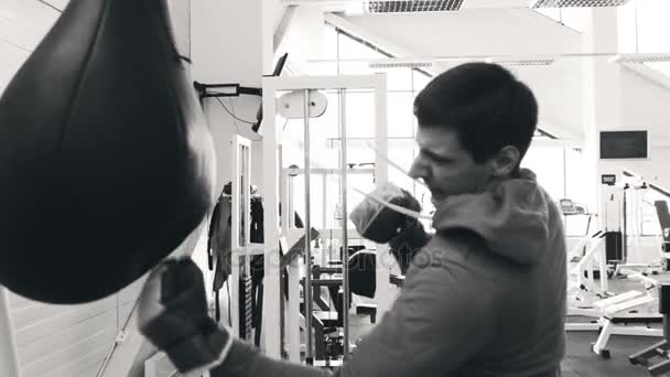 Slow motion of young boxer man practicing on a punching bag in sport fitness club — Stock Video