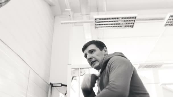Ağır çekim genç boksör adamın kum torbasına spor fitness Club üzerinde pratik — Stok video