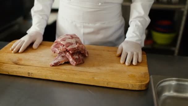 Closeup of professional chef prepare meat ribs on cutting board at restaurant kitchen — Stock Video