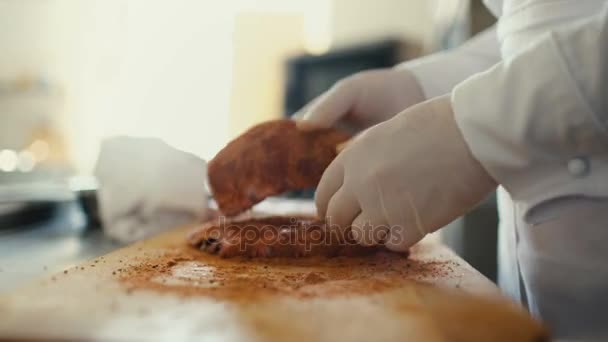 Primer plano del chef profesional hombre preparar costillas de carne con especias en la tabla de cortar en la cocina del restaurante — Vídeo de stock