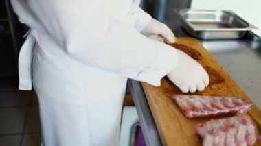 Portre profesyonel şef adamın et kaburga Restoran mutfak at kesme tahtası üzerinde baharat ile hazırlamak