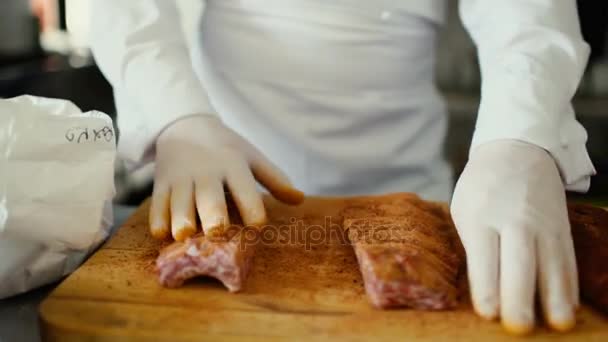 Närbild av professionell kock man förbereda kött revbensspjäll med spice på skärbrädan restaurang Kitchen — Stockvideo