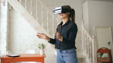 Yukarıya bakıyor ve sanal gerçeklik evde kapalı nesneleri dokunmak çalışırken Vr kulaklık kadında