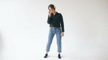 Müzik dinleme ve beyaz arka plan üzerinde kapalı dans kulaklık ile genç kadın