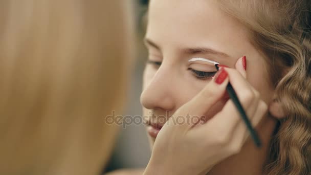 Maquillaje artista hace joven actriz chica hermoso maquillaje para los ojos antes de bailar perfomance en interiores — Vídeos de Stock