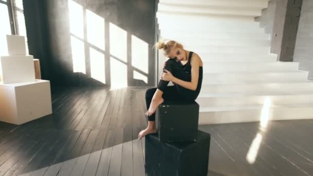 Молода дівчина-підліток танцюрист плаче після втрати парфумерії сидить на кубиках прикраси в танцювальній студії в приміщенні — стокове відео