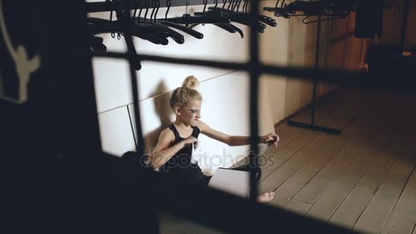 Giovane ragazza adolescente ballerina piangendo e strappando libro si siede sul pavimento in sala al chiuso — Video Stock