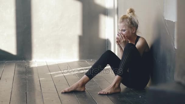 Joven bailarina adolescente es muy enojado y el sufrimiento después de la pérdida de fundición se sienta en el suelo en el estudio de baile en el interior — Vídeos de Stock