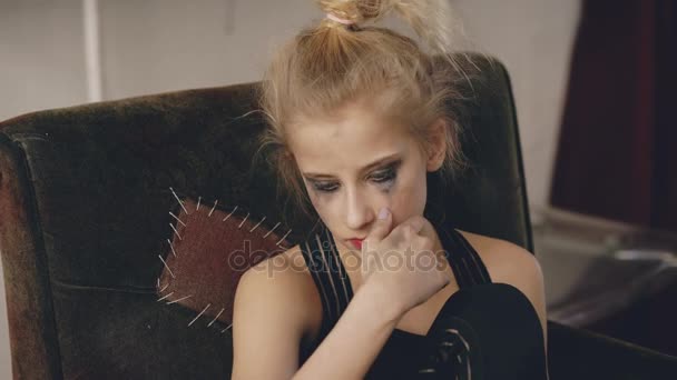 Молодая актриса-подросток с размазанным макияжем плачет после проигрыша кастинг фильма сидит в кресле в студии в помещении — стоковое видео