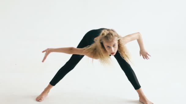 Cámara lenta de hermosa bailarina adolescente bailando contemporáneo sobre fondo blanco en interiores — Vídeos de Stock