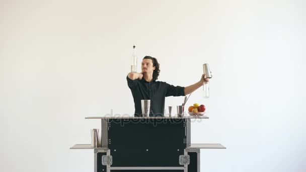 Professionale barista uomo bottiglie giocoleria e cocktail agitazione al tavolo da bar mobile su sfondo bianco — Video Stock