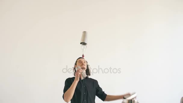 Άνθρωπος μπάρμαν professinal juggling μπουκάλια και τίναγμα κοκτέιλ στο μπαρ κινητό τραπέζι σε άσπρο φόντο — Αρχείο Βίντεο
