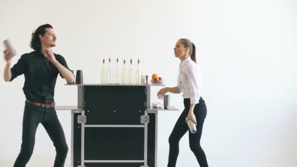 Professeur barman homme et femme jonglant bouteilles et cocktail secouant à la table de bar mobile sur fond blanc — Video