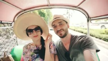 Şapkalı Kız arkadaşıyla yakışıklı delikanlı selfie smartphone alarak geleneksel Tay otobüs songteo binmek. Çift balayı sırasında Tayland seyahat