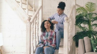 İki Afro-Amerikan kıvırcık kız sistres yapmak kıvırcık saç modeli her diğer eğlenceli ve eğlenceli evde var