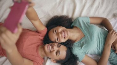 Güzel karışık yarış komik kız yatak odası evde yatakta selfie portre yapma Üstten Görünüm