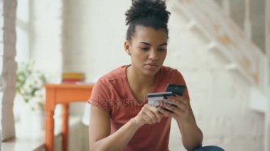 Güzel mutlu karışık ırk kadın online banka kredi kartı ile evde yaşam tarzı alışveriş online smartphone kullanarak
