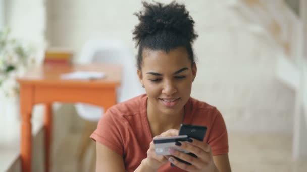 Hermosa mujer de raza mixta feliz banca en línea utilizando el teléfono inteligente de compras en línea con tarjeta de crédito en el hogar — Vídeo de stock