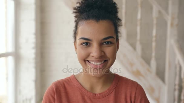 Vértes portréja szép afro-amerikai lány nevetett, és vizsgálja a kamera. Nő kimutatják érzelmeiket, a sorozat arc nevetni otthon