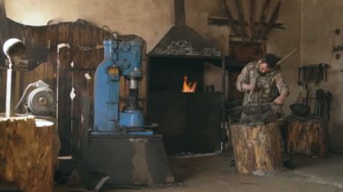 El ile sıcak metal bıçak geleneksel smithy örs üzerinde dövme demirci genç adam