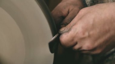 Eller geleneksel smithy değirmentaşı makine metal bıçak bileme closeup