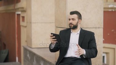 Genç iş adamı görüntülü sohbet iş toplantısı tablet bilgisayarda konuşmaya sakallı. Video konferans görüşme için App kullanarak iş adamı