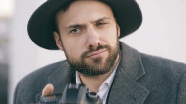 Şüpheli genç photogpraher adam alarak resmin. Hippi erkek casus Ajan fotoğraf çekimi ve kameraya bakarak şapkalı kavramı